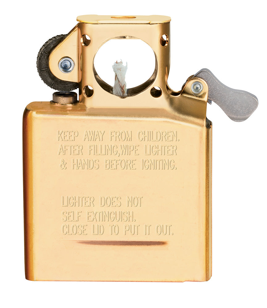Ein goldfarbener Zippo-Feuerzeugeinsatz mit Zündmechanismus zeigt Text: "KEEP AWAY FROM CHILDREN. AFTER FILLING, WIPE LIGHTER & HANDS BEFORE IGNITING. LIGHTER DOES NOT SELF EXTINGUISH. CLOSE LID TO PUT IT OUT."