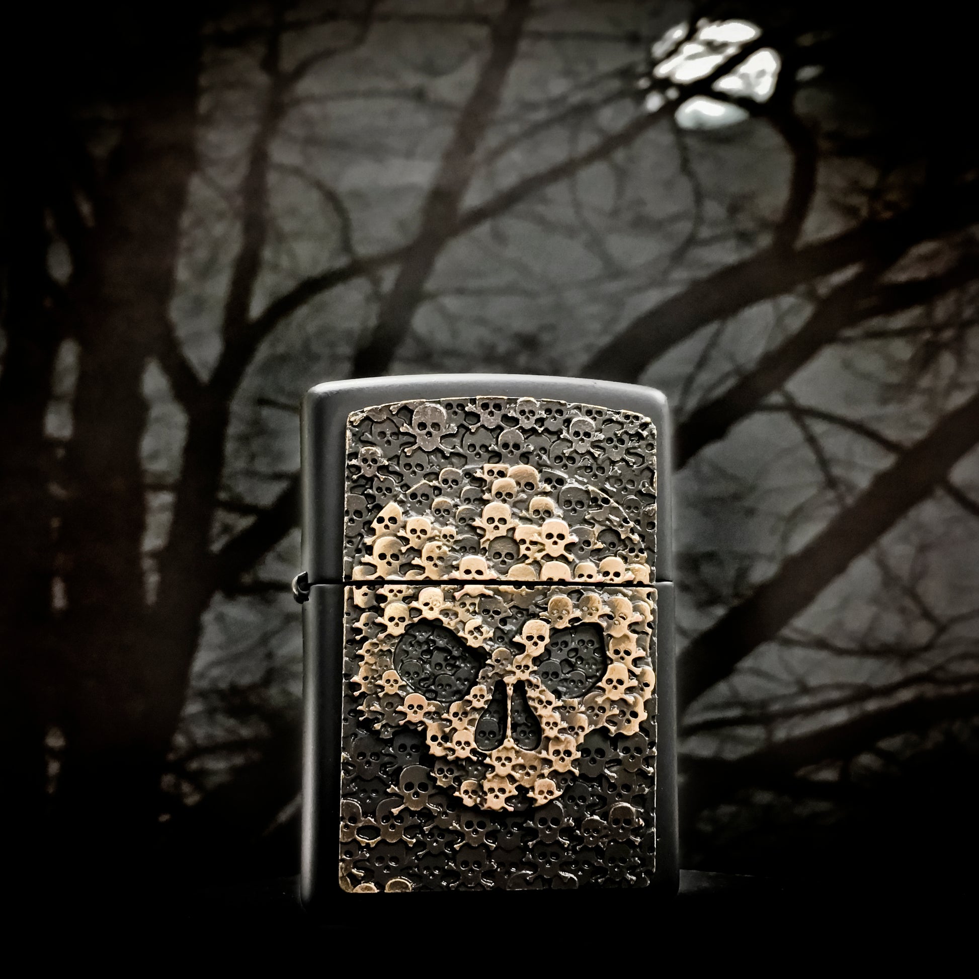 Frontansicht Zippo Feuerzeug schwarz Totenkopf bestehend aus vielen kleinen Totenköpfen Emblem mit illustriertem Hintergrund